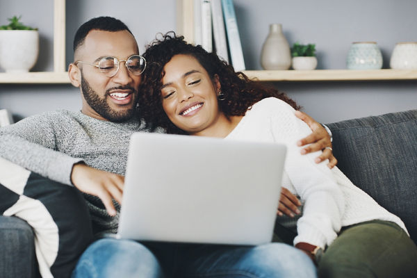 Young couple relaxing at home on a laptop