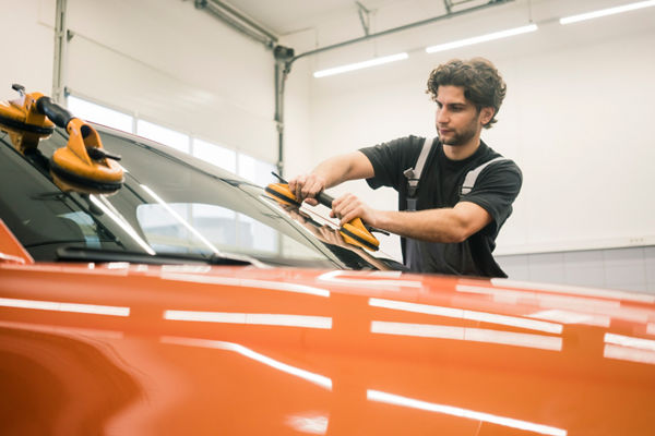 Car mechanic in a workshop changing car window
