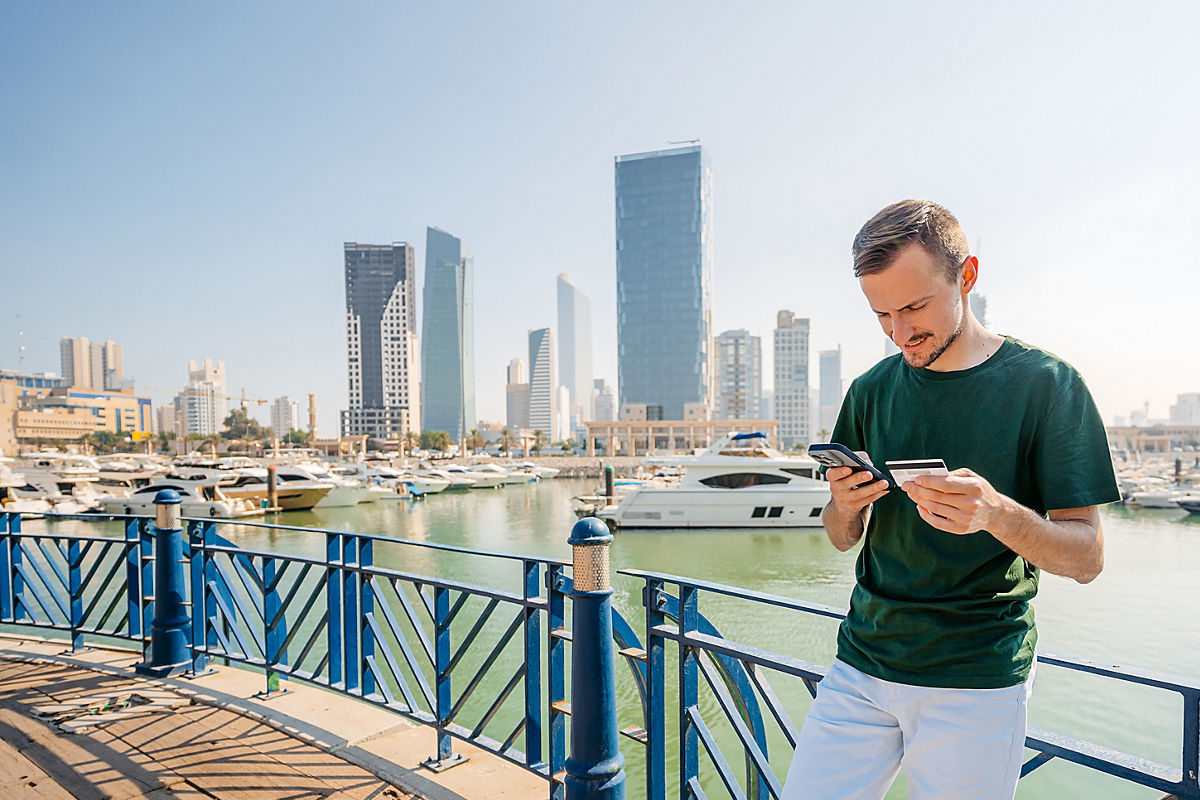 Young man shopping on phone using a credit card
