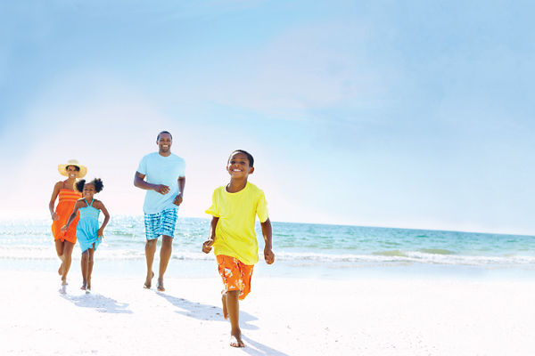 Boy racing family on the beach