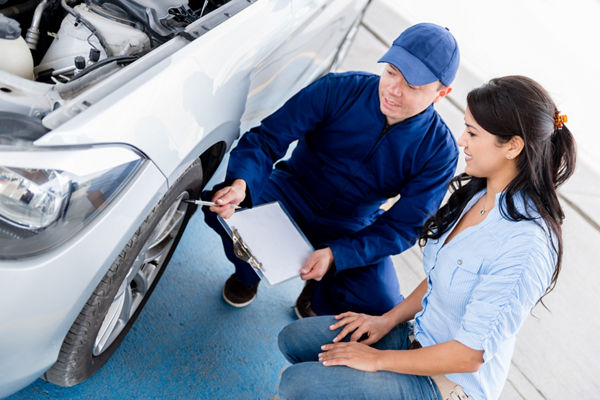 Auto mechanic speaking to customer